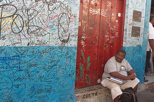 Graffiti-Covered Wall with Seated Man