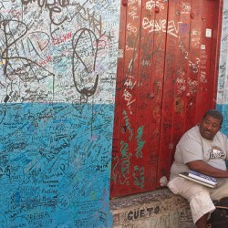 Graffiti-Covered Wall with Seated Man